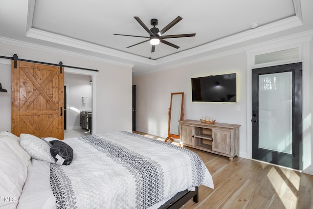 257 Rawhide Dr, Louisburg, NC 27549 - bedroom with a tray ceiling, a barn door, crown molding, light wood-style flooring, and ceiling fan
