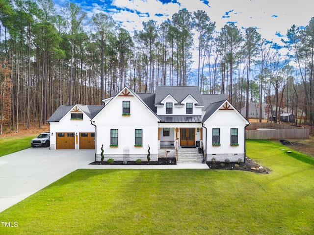 257 Rawhide Dr, Louisburg, NC 27549 - modern inspired farmhouse featuring covered porch, a standing seam roof, a front lawn, a metal roof, and concrete driveway