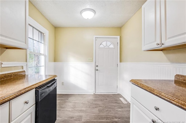 334 Richmond Dr, Fayetteville, NC 28304 - kitchen with black dishwasher, wainscoting, dark countertops, wood finished floors, and white cabinetry
