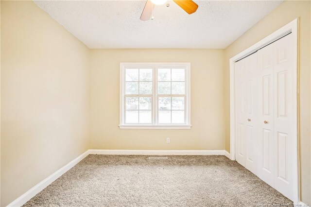 334 Richmond Dr, Fayetteville, NC 28304 - unfurnished bedroom featuring carpet flooring, a textured ceiling, a closet, and ceiling fan
