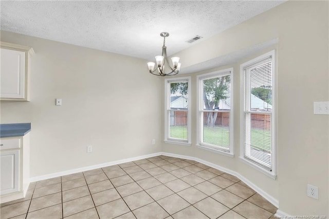 6324 Foxlake Dr, Fayetteville, NC 28314 - unfurnished dining area with a chandelier, healthy amount of natural light, light tile patterned floors, and a textured ceiling