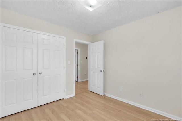 6324 Foxlake Dr, Fayetteville, NC 28314 - unfurnished bedroom featuring light wood-style flooring, a closet, and a textured ceiling