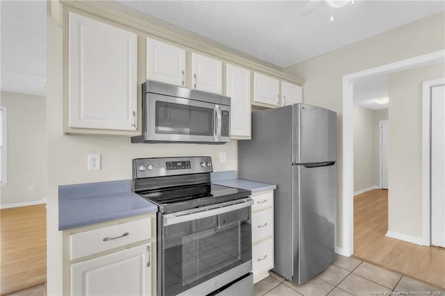 6324 Foxlake Dr, Fayetteville, NC 28314 - kitchen featuring stainless steel appliances, white cabinetry, light countertops, light tile patterned floors, and ceiling fan