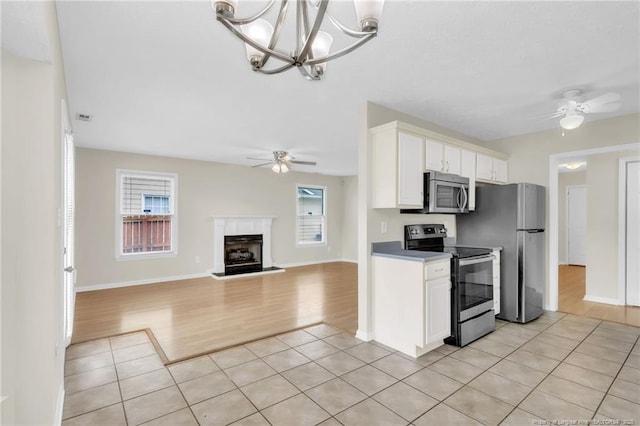6324 Foxlake Dr, Fayetteville, NC 28314 - kitchen featuring stainless steel appliances, a ceiling fan, light wood-style flooring, and white cabinets