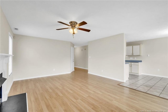 6324 Foxlake Dr, Fayetteville, NC 28314 - unfurnished living room with a ceiling fan, a fireplace, and light wood-type flooring