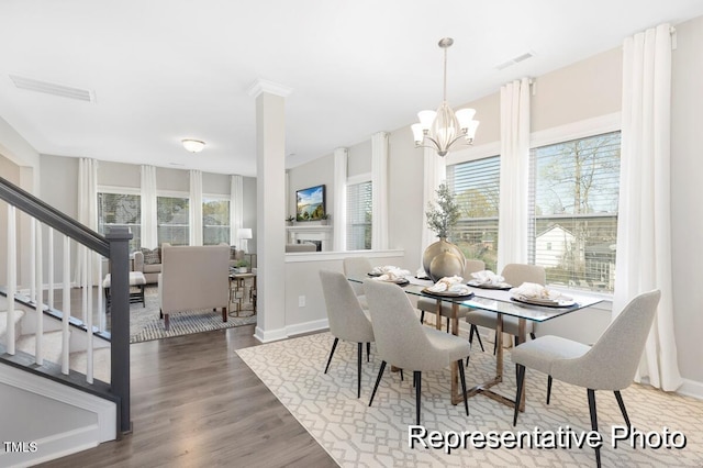 59 Curling Creek Dr Unit I285, Clayton, NC 27527 - dining room featuring healthy amount of natural light, stairway, wood finished floors, and a chandelier