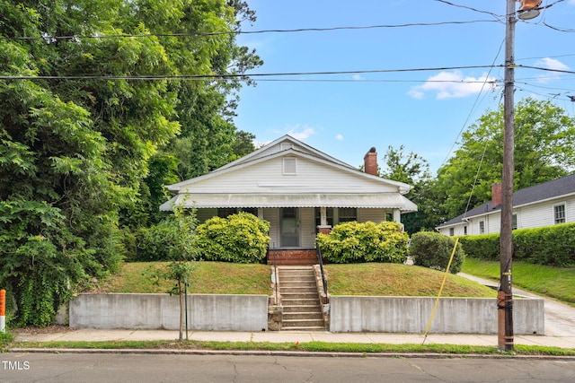 907 Morehead Ave, Durham, NC 27707 - bungalow-style house with a front yard, stairway, a chimney, and a porch