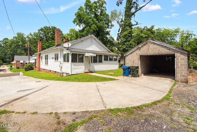 907 Morehead Ave, Durham, NC 27707 - view of front facade featuring a garage, an outdoor structure, a chimney, and a front yard