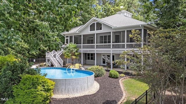 1221 Sagamore Dr, Louisburg, NC 27549 - back of house featuring a sunroom, stairway, a shingled roof, and a fenced backyard
