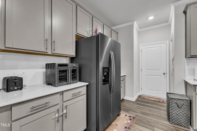 220 Garden Vine Trl, Raleigh, NC 27610 - kitchen with stainless steel refrigerator with ice dispenser, ornamental molding, gray cabinets, backsplash, and light wood finished floors