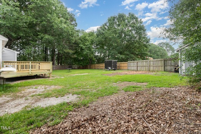 204 Valley Ct, Selma, NC 27576 - fenced backyard featuring a wooden deck, a storage shed, and view of wooded area