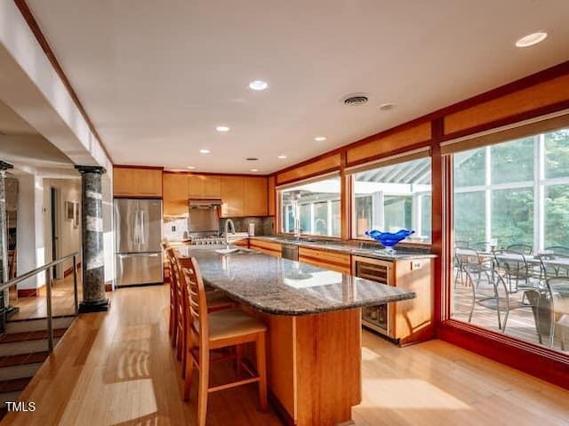 64 Robin Rd, Semora, NC 27343 - kitchen featuring appliances with stainless steel finishes, beverage cooler, light wood-type flooring, dark stone countertops, and recessed lighting