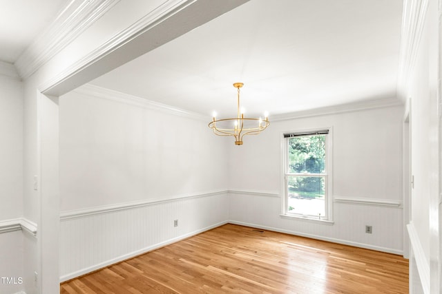 212 Heidinger Dr, Cary, NC 27511 - empty room featuring a chandelier, wood finished floors, a wainscoted wall, and crown molding
