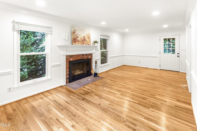212 Heidinger Dr, Cary, NC 27511 - unfurnished living room featuring ornamental molding, healthy amount of natural light, a brick fireplace, light wood-style floors, and recessed lighting