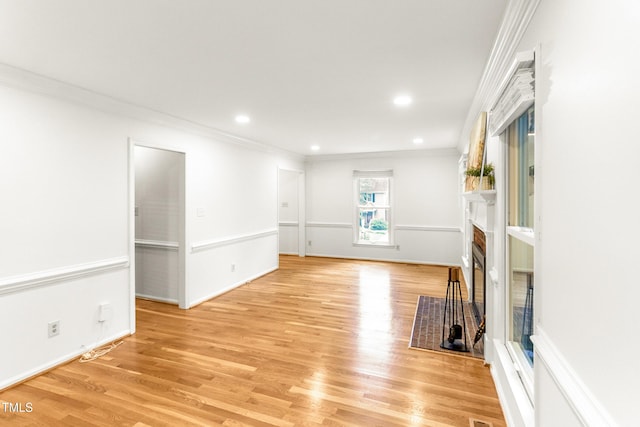 212 Heidinger Dr, Cary, NC 27511 - unfurnished living room featuring crown molding, light wood finished floors, a fireplace with flush hearth, and recessed lighting
