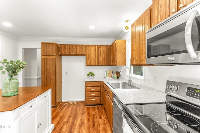 212 Heidinger Dr, Cary, NC 27511 - kitchen with appliances with stainless steel finishes, ornamental molding, brown cabinetry, light wood-style flooring, and white cabinets