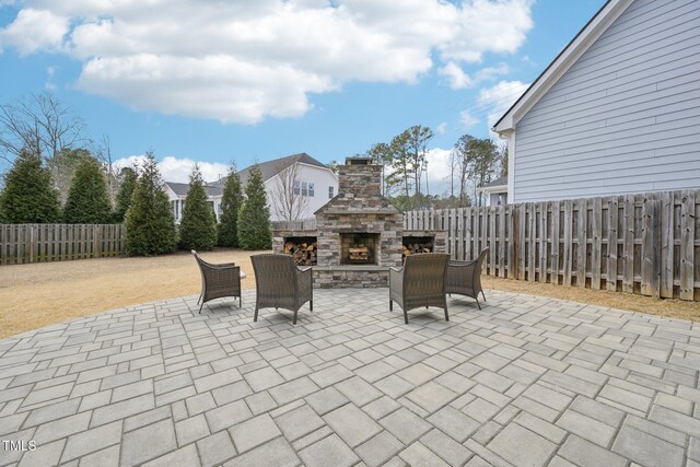 1985 Firenza Dr, Apex, NC 27502 - fenced backyard with a patio and an outdoor stone fireplace