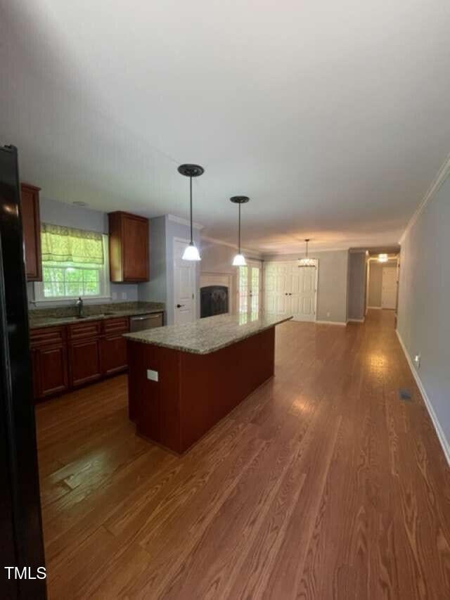 512 Crestview Dr, Durham, NC 27712 - kitchen featuring a kitchen island, dark wood-style floors, stainless steel dishwasher, open floor plan, and hanging light fixtures