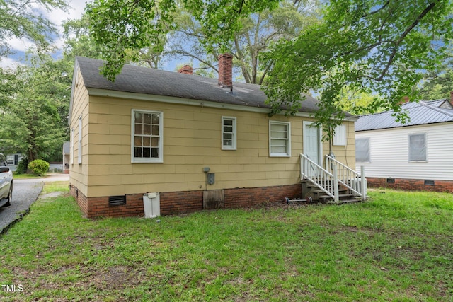 720 Spruce St, Laurinburg, NC 28352 - back of house featuring entry steps, crawl space, a chimney, and a lawn