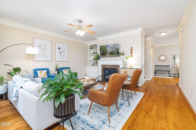 10906 Flower Bed Ct, Raleigh, NC 27614 - living area featuring ceiling fan, crown molding, light wood-style flooring, a premium fireplace, and built in features