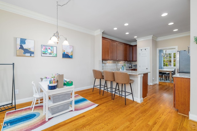 10906 Flower Bed Ct, Raleigh, NC 27614 - kitchen featuring crown molding, a kitchen breakfast bar, a peninsula, tasteful backsplash, and recessed lighting