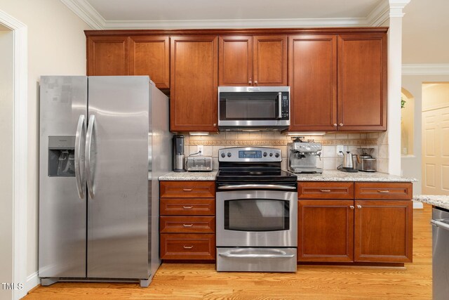 10906 Flower Bed Ct, Raleigh, NC 27614 - kitchen featuring stainless steel appliances, crown molding, decorative backsplash, light wood-type flooring, and light stone counters