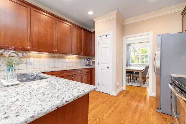 10906 Flower Bed Ct, Raleigh, NC 27614 - kitchen featuring range, light wood-style floors, crown molding, decorative backsplash, and light stone countertops