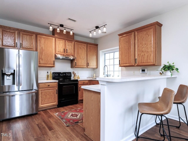 1103 Mallory Ln, Durham, NC 27713 - kitchen featuring stainless steel refrigerator with ice dispenser, black electric range, under cabinet range hood, a peninsula, and dark wood-style floors