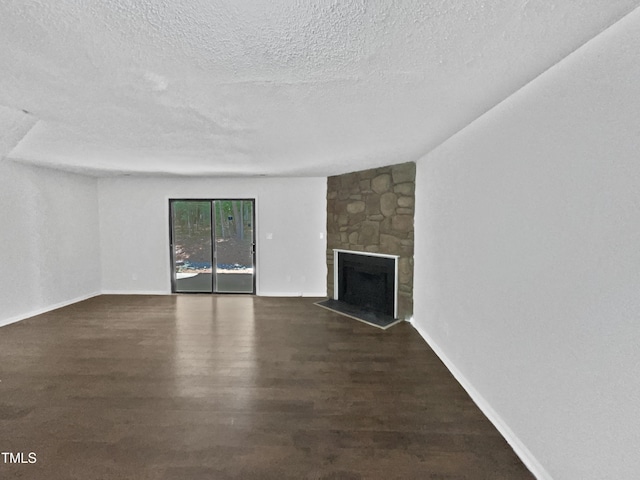 104 Mossbark Ln, Chapel Hill, NC 27514 - unfurnished living room with a textured ceiling, a stone fireplace, and wood finished floors