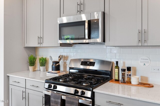 1143 Weavers Trace Dr, Zebulon, NC 27597 - kitchen with stainless steel appliances, light stone counters, and backsplash