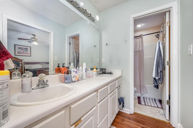 1261 Grovewood Dr, Clayton, NC 27520 - bathroom featuring double vanity, wood finished floors, ceiling fan, and shower / bath combo with shower curtain