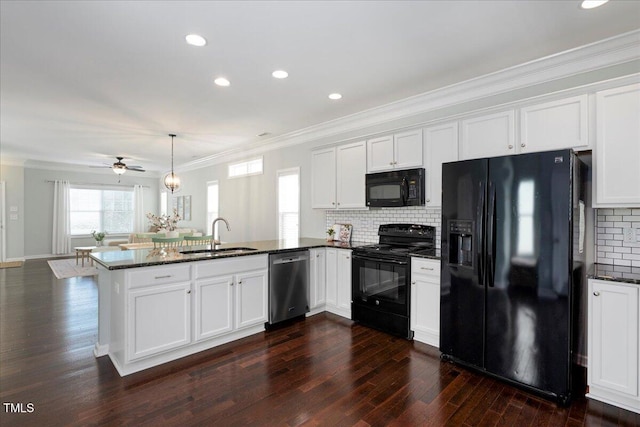 979 Branch Line Ln, Apex, NC 27502 - kitchen with black appliances, a peninsula, dark wood finished floors, dark stone countertops, and crown molding