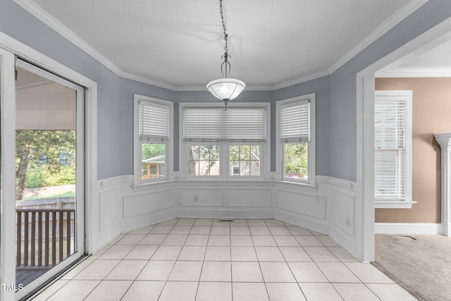 2205 Bufflehead Rd, Raleigh, NC 27616 - unfurnished dining area featuring a textured ceiling, a wainscoted wall, crown molding, and light tile patterned flooring