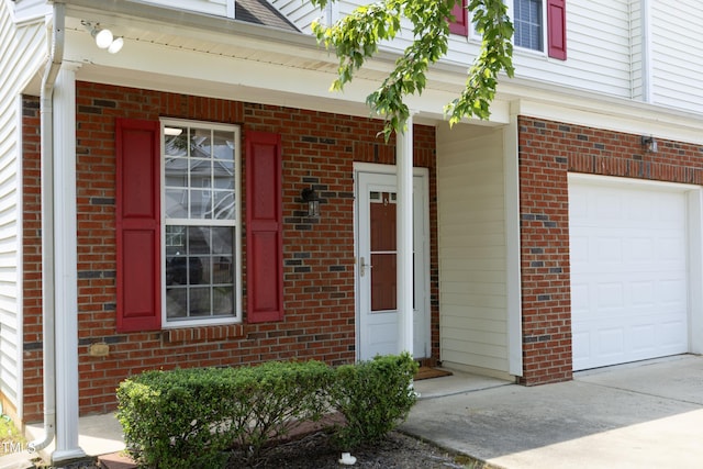 617 Woodson Dr, Clayton, NC 27527 - doorway to property with brick siding, a garage, driveway, and a porch