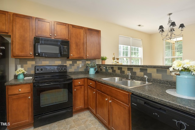 617 Woodson Dr, Clayton, NC 27527 - kitchen featuring black appliances, backsplash, a chandelier, and dark countertops