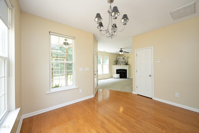 617 Woodson Dr, Clayton, NC 27527 - unfurnished dining area featuring a fireplace, a chandelier, light wood-style flooring, and ceiling fan