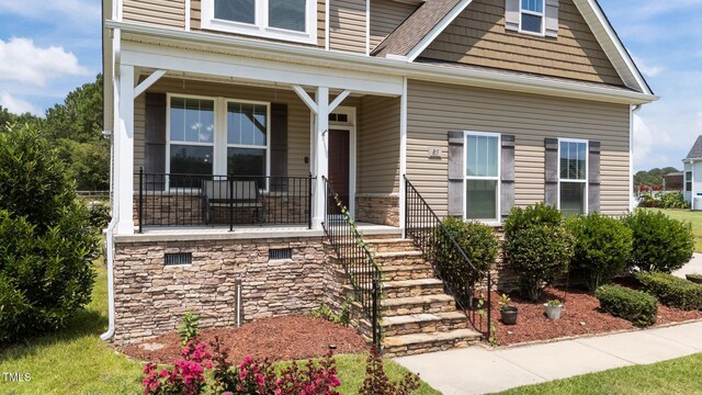 85 Twelve Oaks Dr, Willow Springs, NC 27592 - view of front of home featuring covered porch, stairs, stone siding, and roof with shingles
