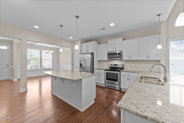85 Twelve Oaks Dr, Willow Springs, NC 27592 - kitchen with stainless steel appliances, dark wood-style floors, light stone counters, white cabinetry, and a chandelier