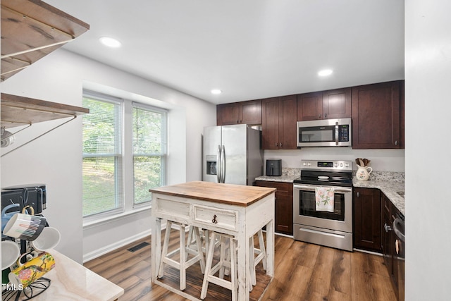 7286 Shellburne Dr, Raleigh, NC 27612 - kitchen with stainless steel appliances, dark brown cabinets, dark wood-style floors, recessed lighting, and light stone countertops