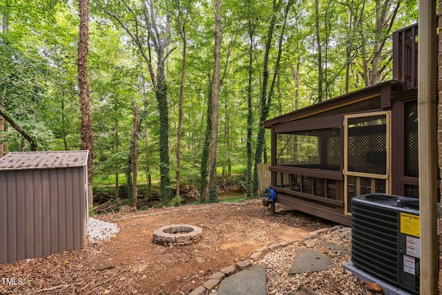 7286 Shellburne Dr, Raleigh, NC 27612 - view of yard featuring an outdoor fire pit, a sunroom, and a view of trees