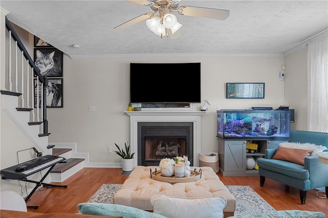 195 Hogart St, Raeford, NC 28376 - living room with stairway, a textured ceiling, wood finished floors, a ceiling fan, and crown molding