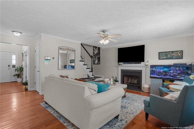 195 Hogart St, Raeford, NC 28376 - living room featuring stairway, a textured ceiling, wood finished floors, ornamental molding, and ceiling fan