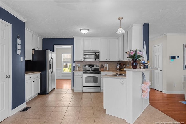 195 Hogart St, Raeford, NC 28376 - kitchen featuring stainless steel appliances, light tile patterned floors, white cabinets, a peninsula, and a textured ceiling