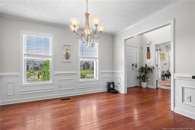 195 Hogart St, Raeford, NC 28376 - unfurnished dining area with a chandelier, a textured ceiling, wood finished floors, and a wainscoted wall