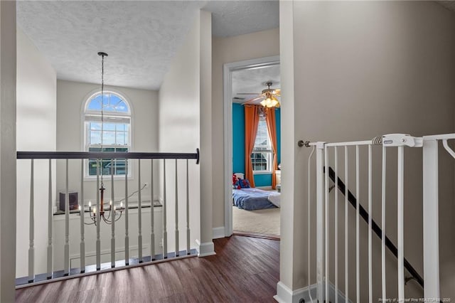 195 Hogart St, Raeford, NC 28376 - hall featuring wood finished floors, a chandelier, an upstairs landing, and a textured ceiling