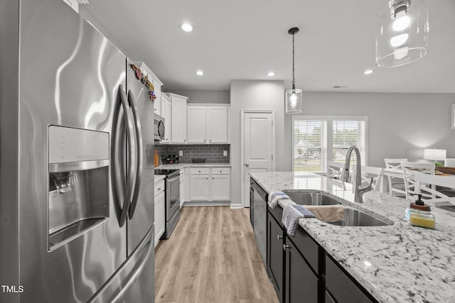 19 Linda Lou Ln Unit 19, Angier, NC 27501 - kitchen with appliances with stainless steel finishes, light wood-style floors, white cabinetry, backsplash, and decorative light fixtures