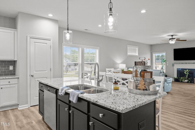 19 Linda Lou Ln Unit 19, Angier, NC 27501 - kitchen with stainless steel dishwasher, open floor plan, light wood finished floors, a center island with sink, and white cabinets