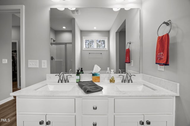 19 Linda Lou Ln Unit 19, Angier, NC 27501 - bathroom with double vanity, a shower stall, a walk in closet, and wood finished floors