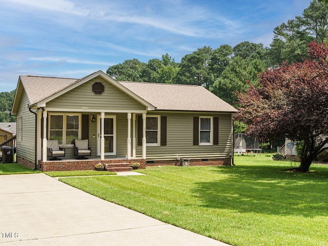 635 Raymond Dr, Wendell, NC 27591 - view of front of house featuring a trampoline, covered porch, crawl space, a front lawn, and a shingled roof