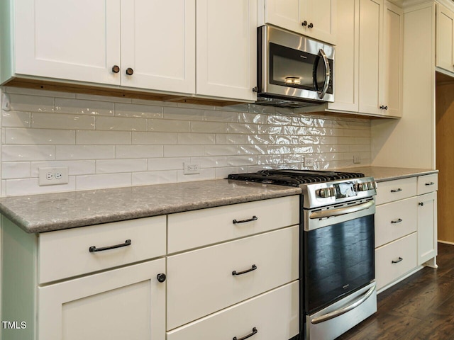 2013 Woodbluff Dr, Wendell, NC 27591 - kitchen with appliances with stainless steel finishes, dark wood-style flooring, decorative backsplash, and white cabinets